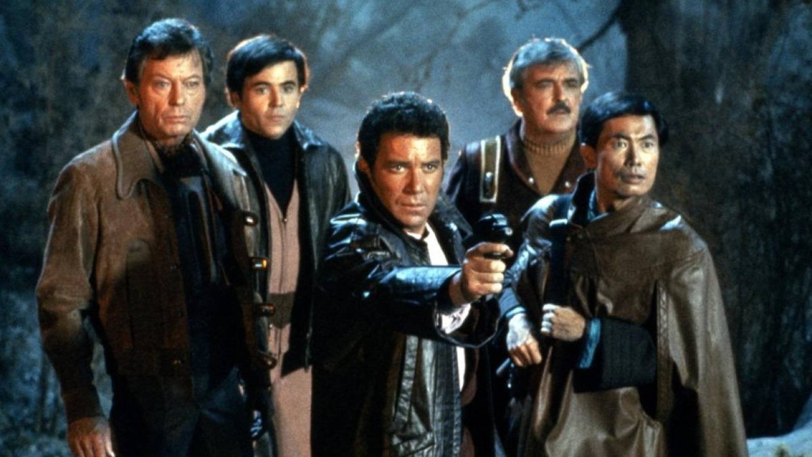 Kirk aims a phaser while the Enterprise crew looks on in Star Trek III: The Search for Spock