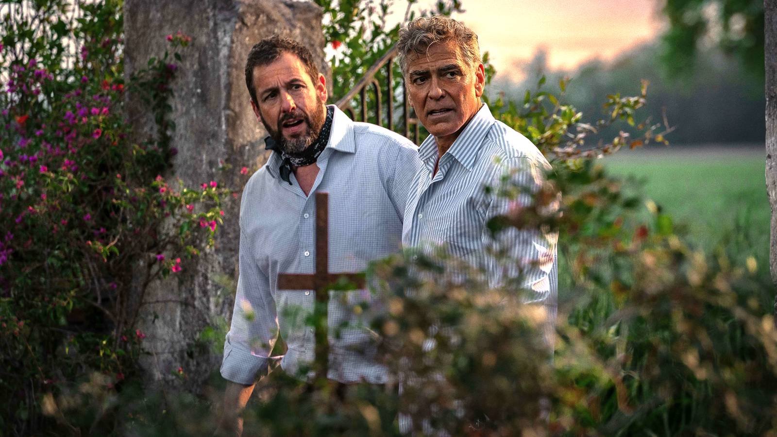 Adam Sandler's Ron and George Clooney's Jay looking disheveled in a garden in Jay Kelly