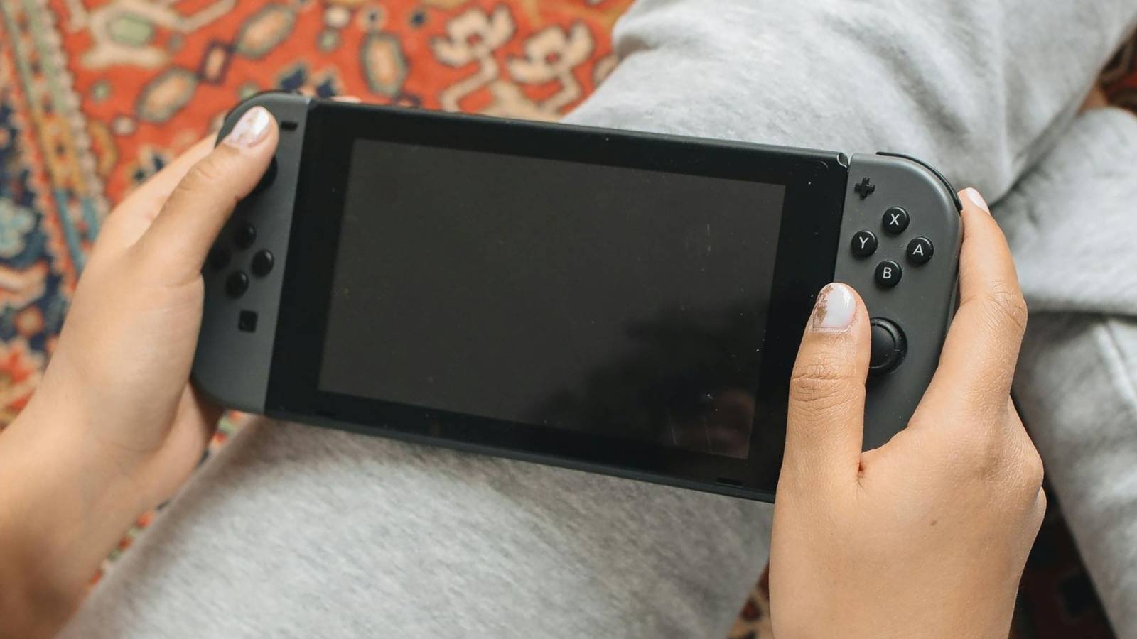 A person holding a Nintendo Switch.