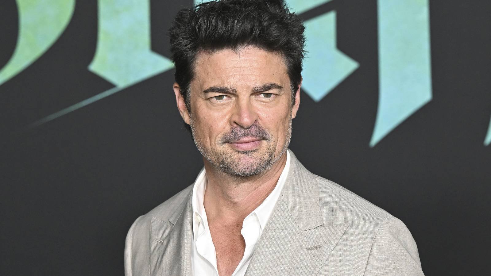 Karl Urban smiling on The Bluff red carpet