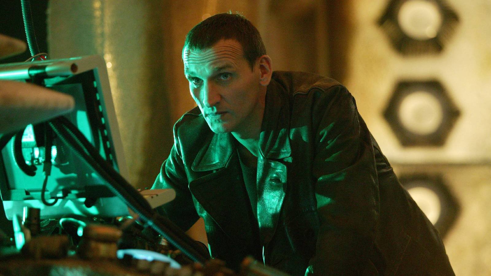 Christopher Eccleston as the Ninth Doctor leaning over a computer in Doctor Who season 1