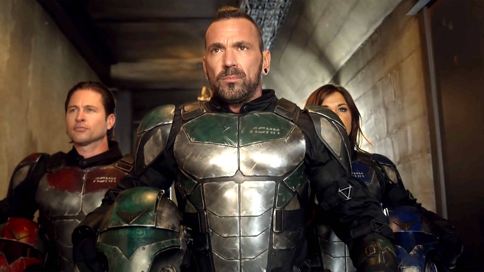 Jason David Frank as Eric walking down a hallway with two people behind him, all in superhero sui...