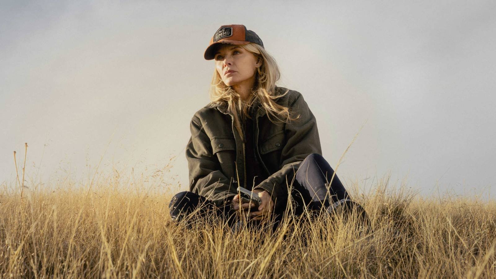 Stacy Clyburn (Michelle Pfeiffer) sitting in the grass in The Madison