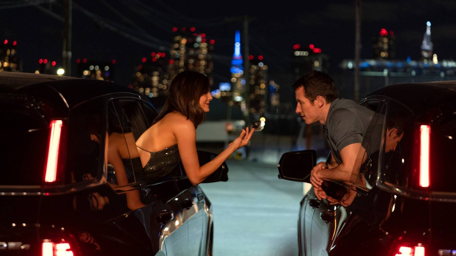 Allie and Owen leaning out car windows to talk to each other in One Night Only