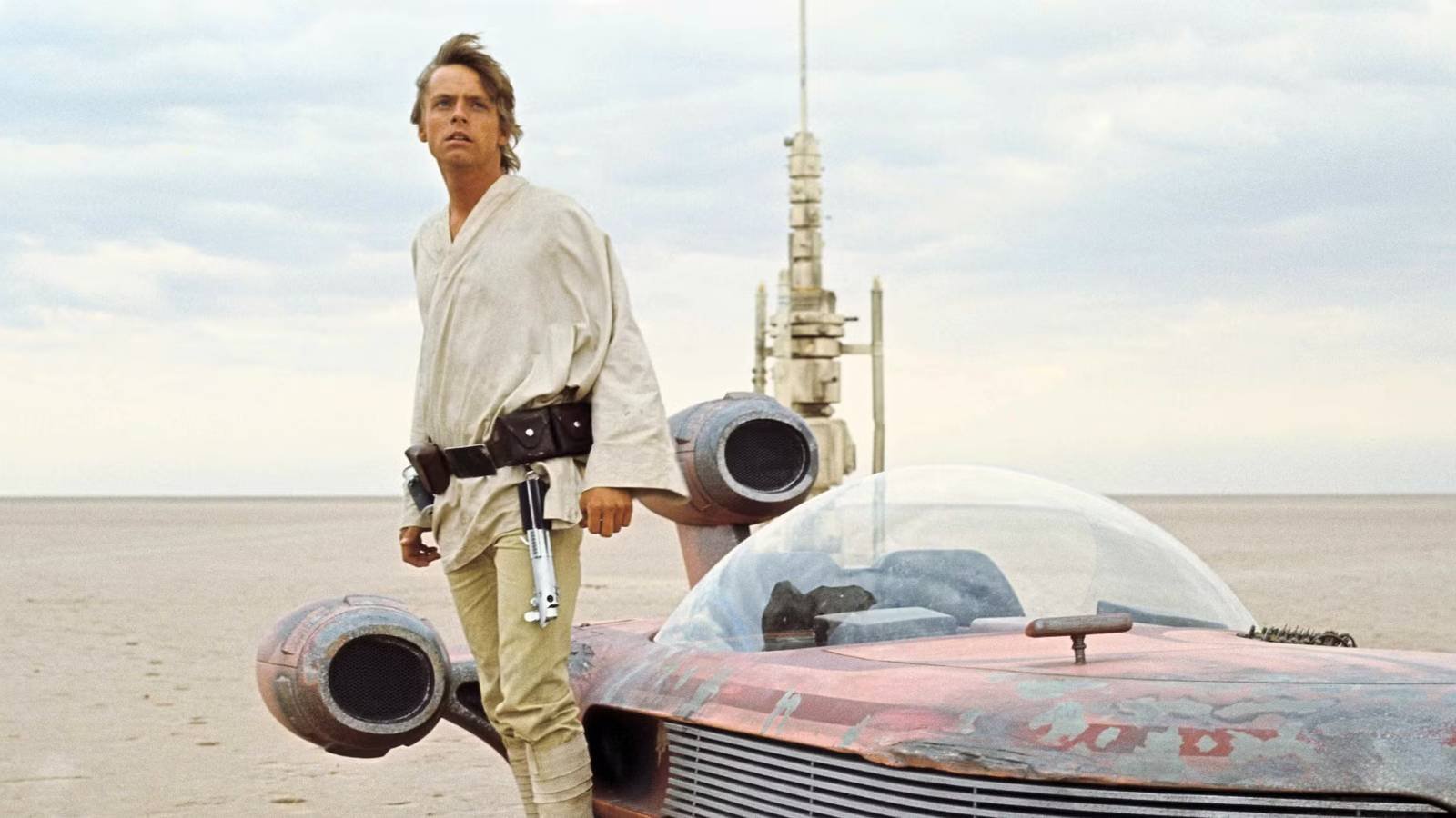 Luke Skywalker standing next to a speeder on Tatooine in A New Hope