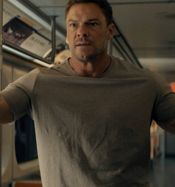 Alan Ritchson as Reacher being held at gunpoint